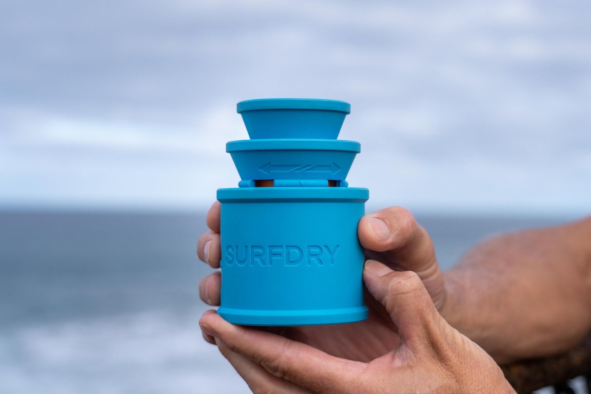 SURFDRY wetsuit dryer held in one hand at the coast - compact and portable